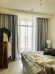 Floor-length home curtains in a UAE bedroom with natural light