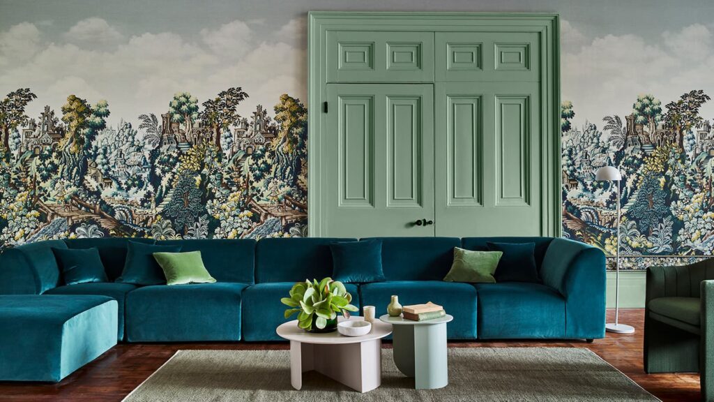 Living room with teal sectional sofa, wall mural, and custom curtains in Dubai